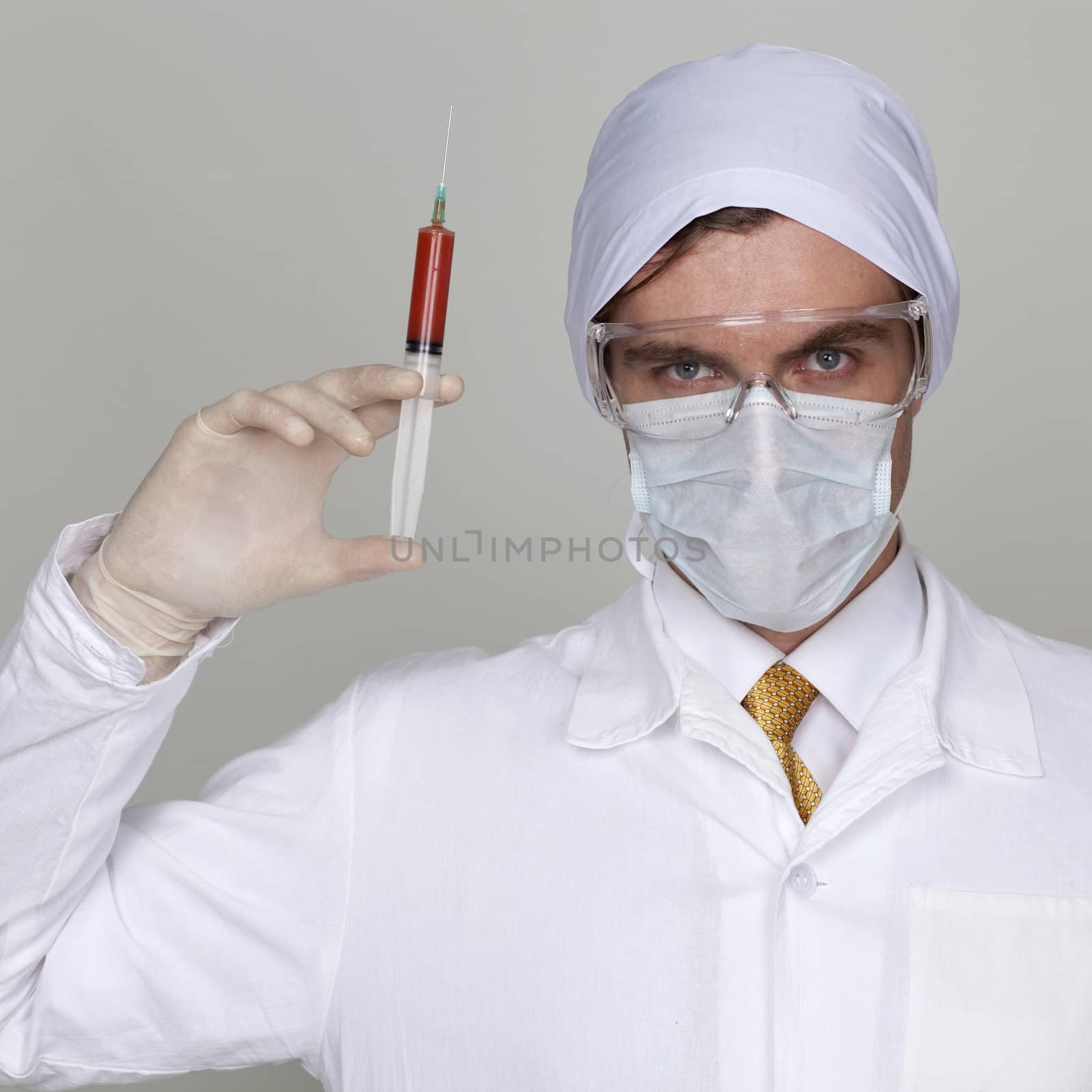 Confident surgeon holding a syringe by andersonrise
