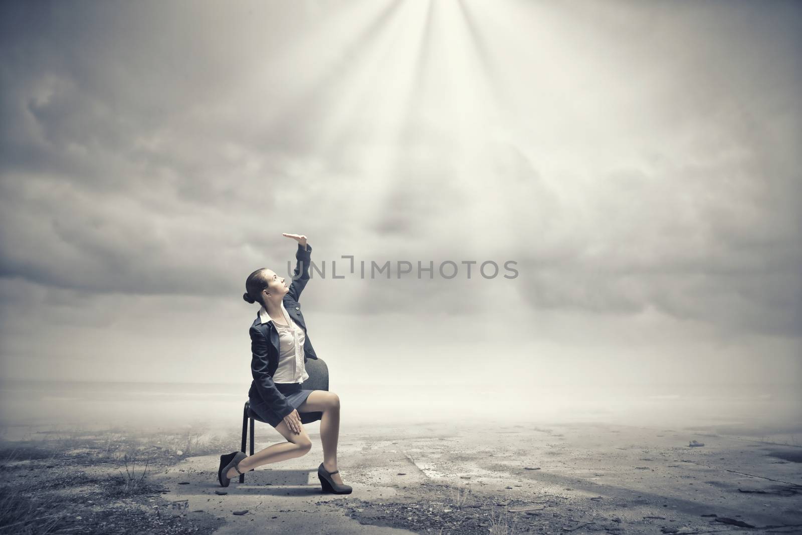 Image of businesswoman sitting on chair under sun lights