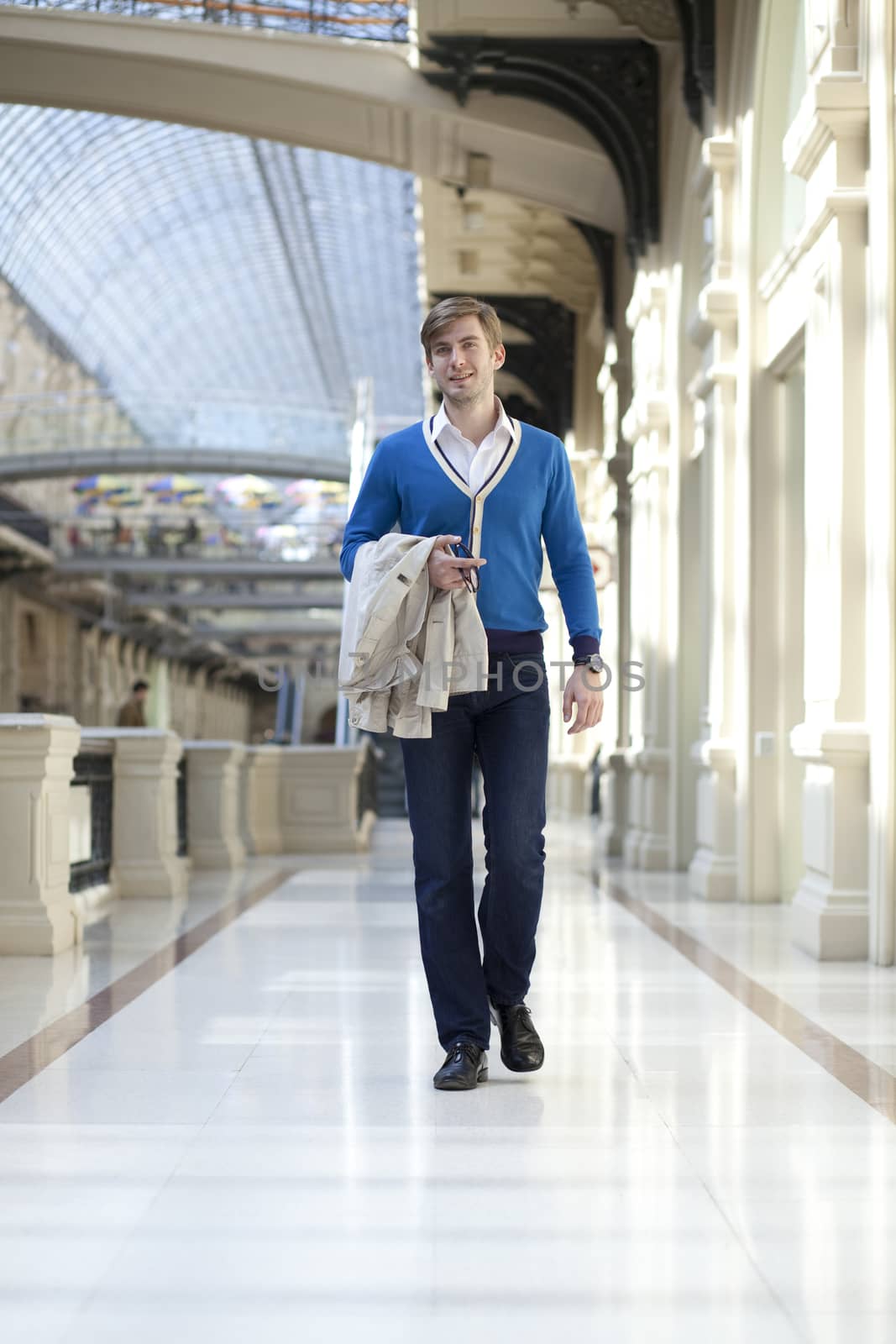 Young man walking in the store by andersonrise