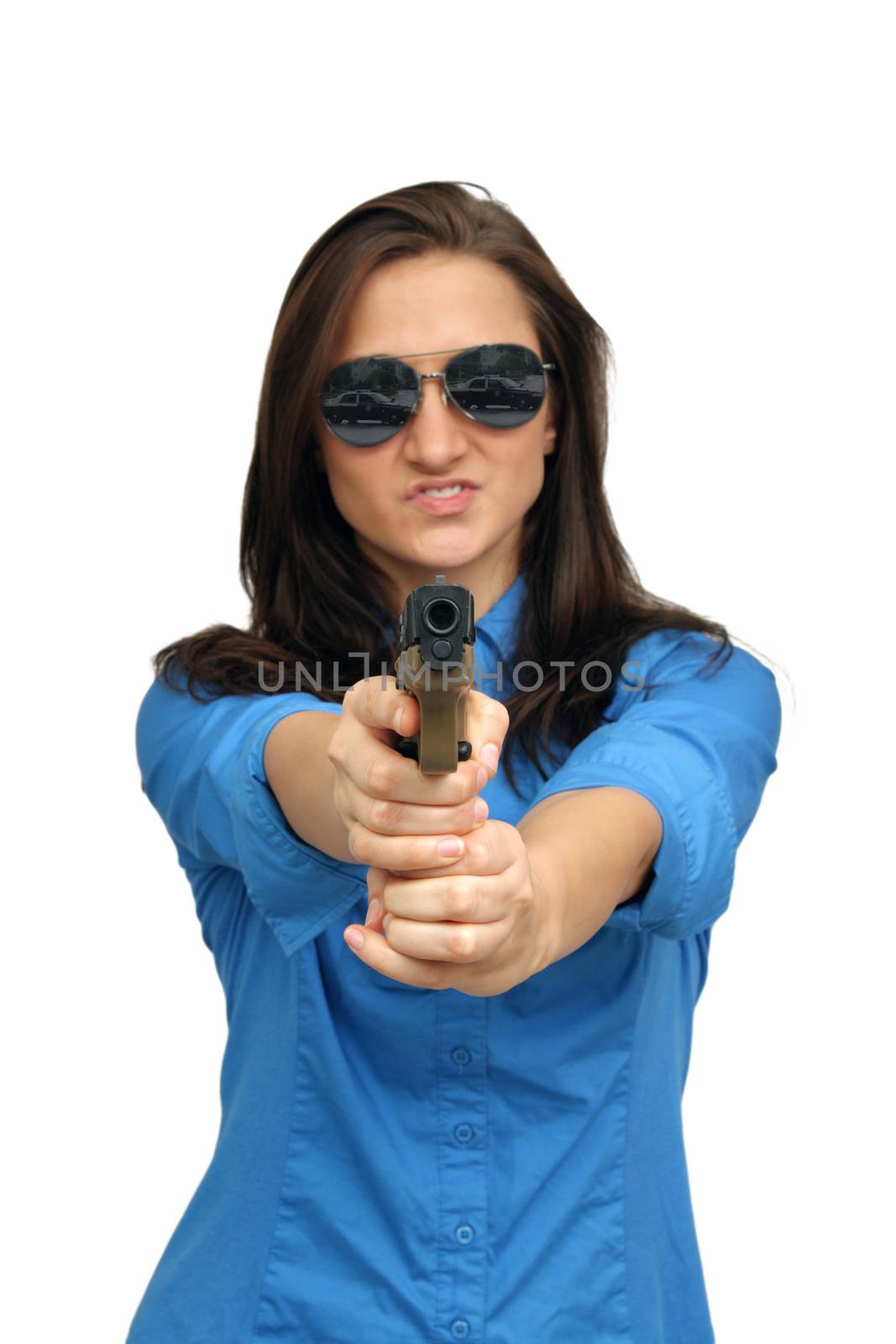 A lovely young brunette points a modern handgun at the camera.  The reflection of a state trooper vehicle is in her sunglasses.  Selective focus on the handgun.  Isolated on a white background with generous copyspace.