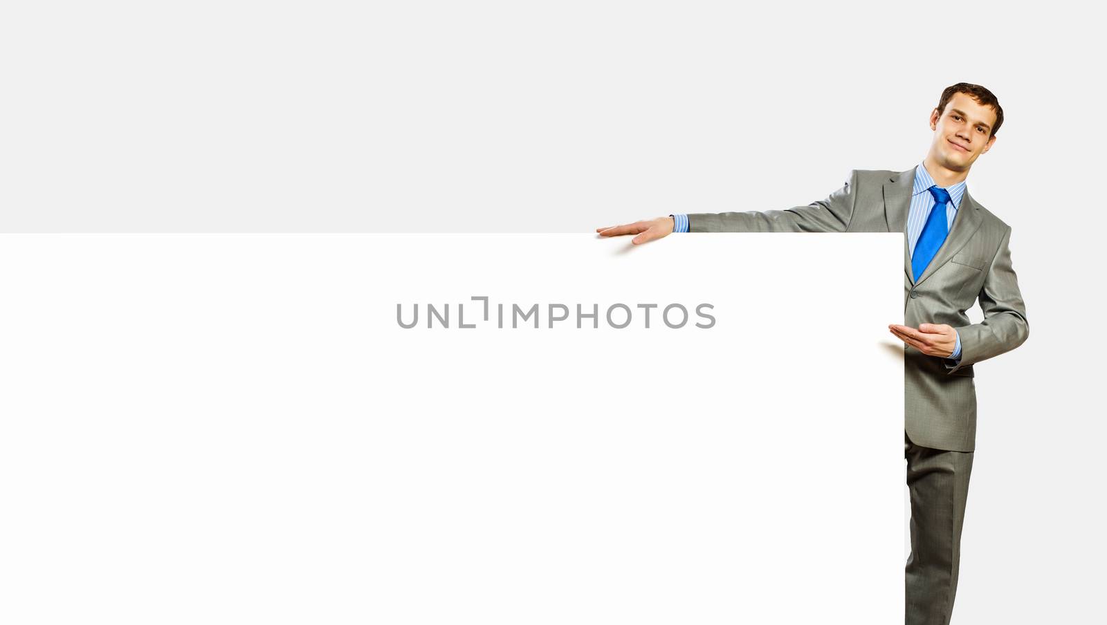 Businessman holding blank banner by sergey_nivens