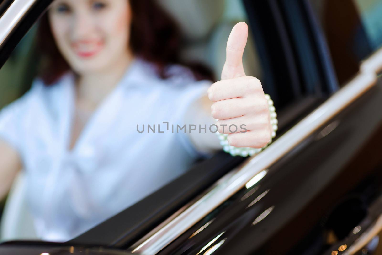 Attractive young woman sitting in car in car center