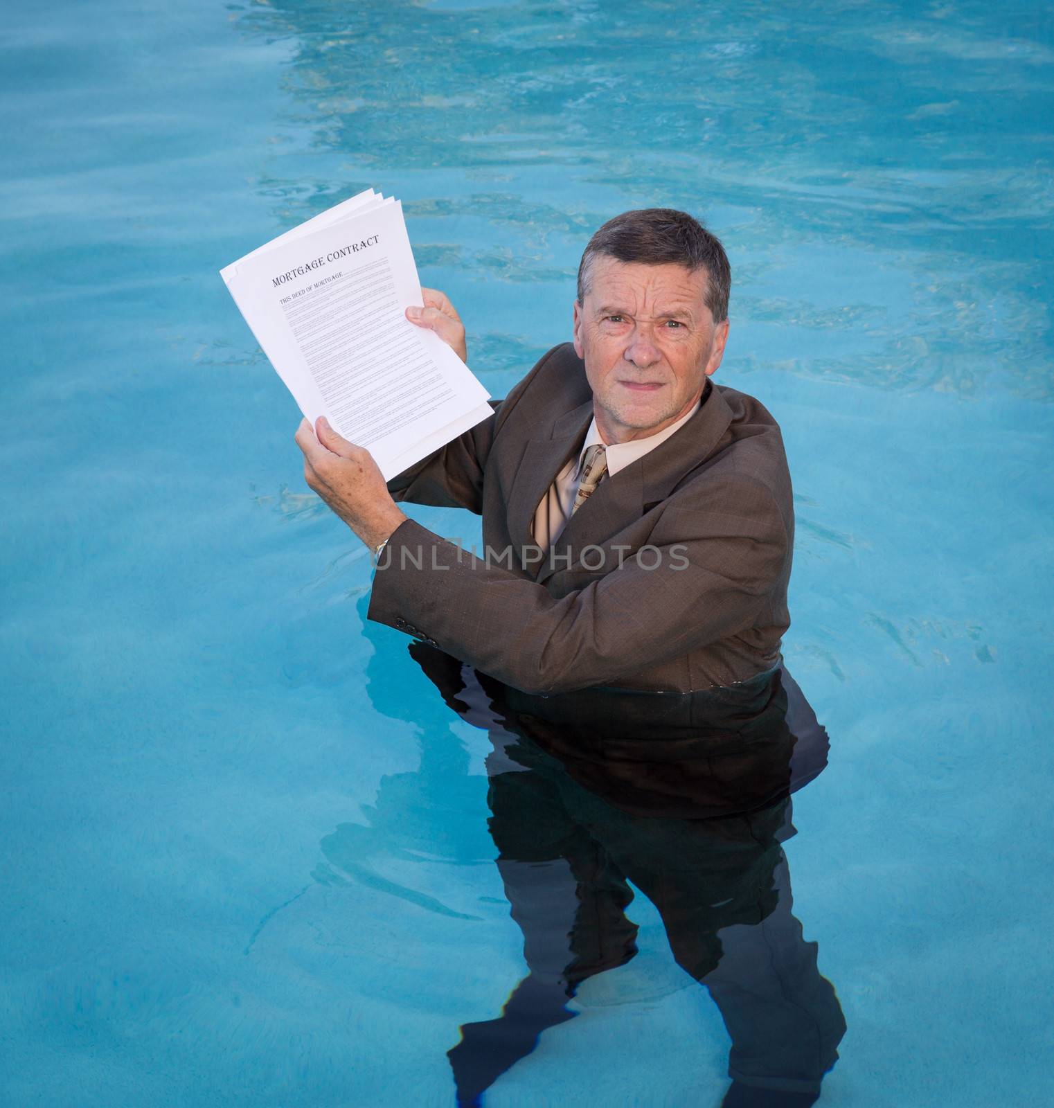 Senior man holding mortgage loan document in water by steheap