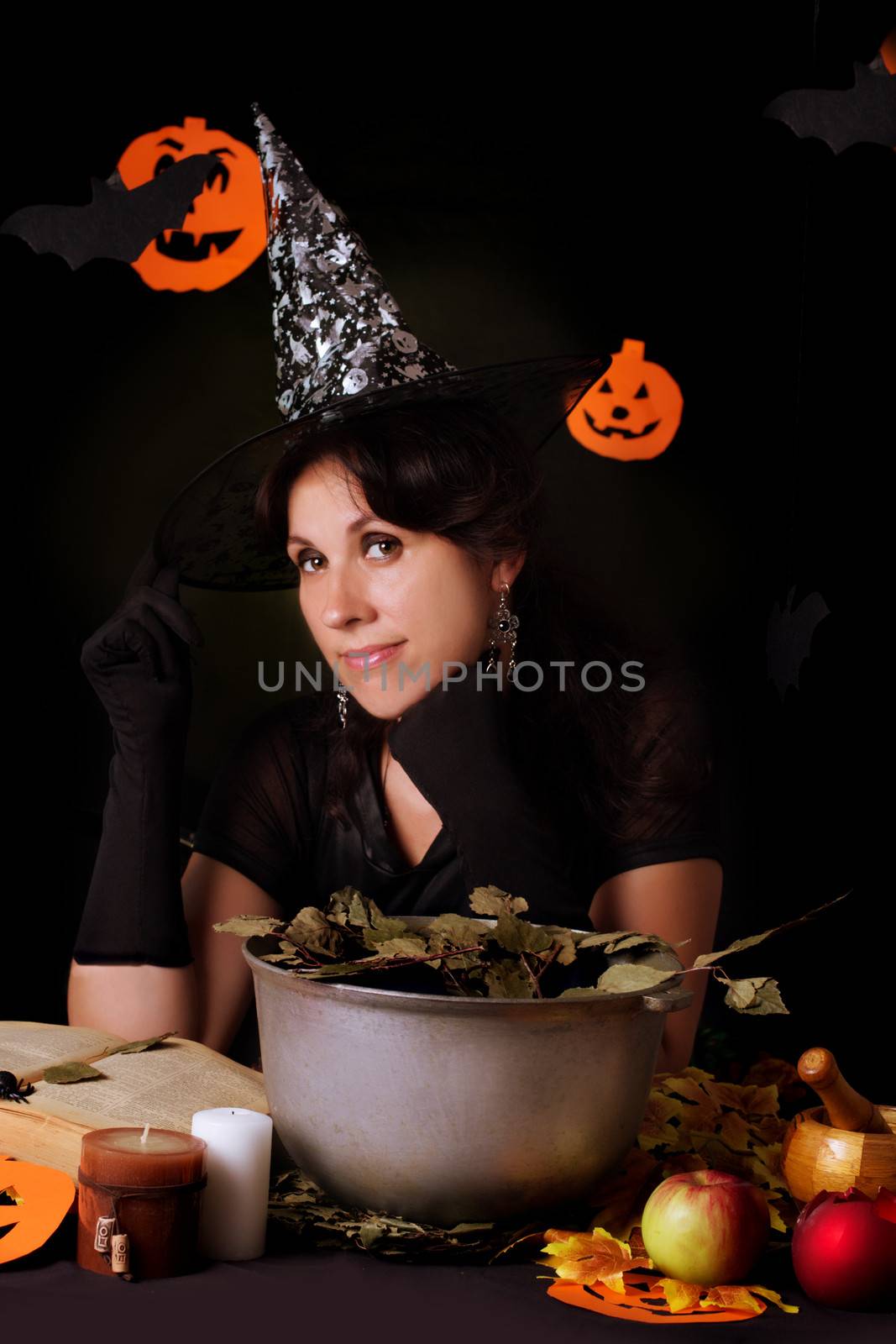 Nice witch practicing sorcery at Halloween night