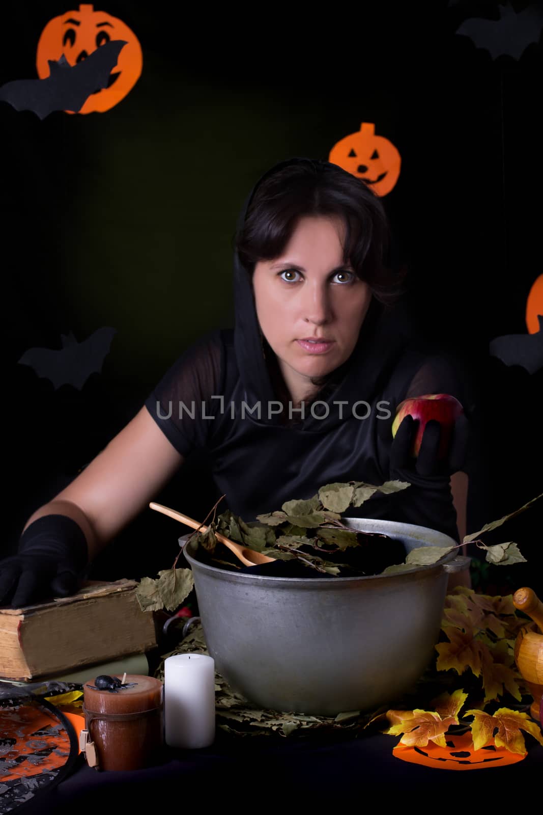 Witch holding poisoned apple at Halloween night