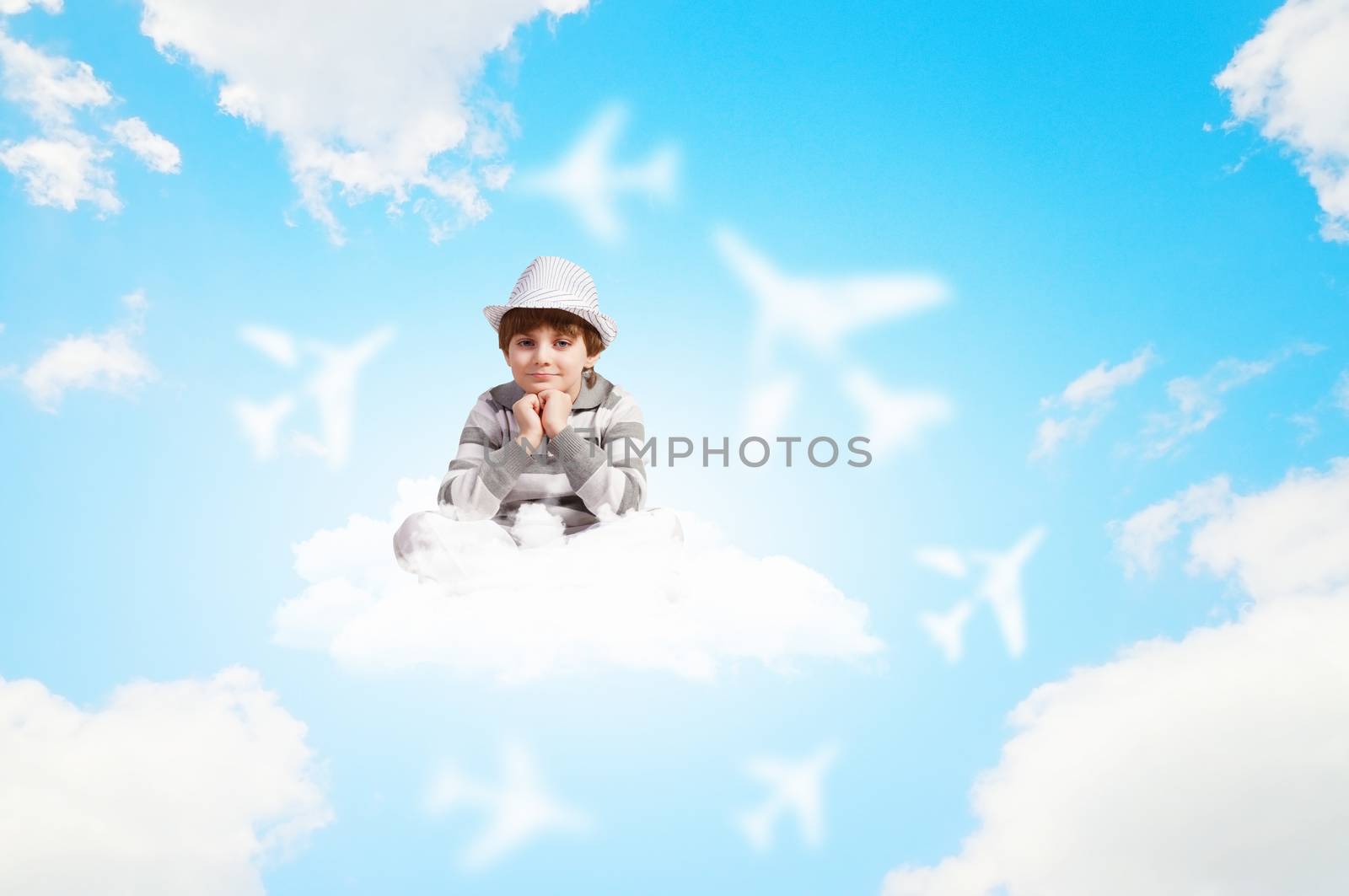 Image of little cute boy smiling sitting on clouds