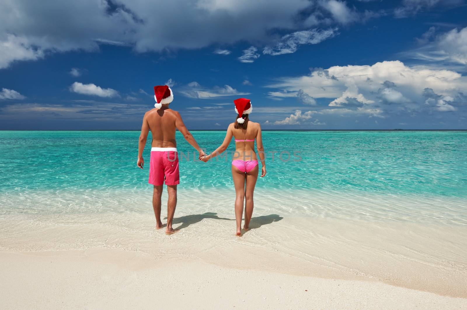 Couple in santa's hat on a beach at Maldives by haveseen