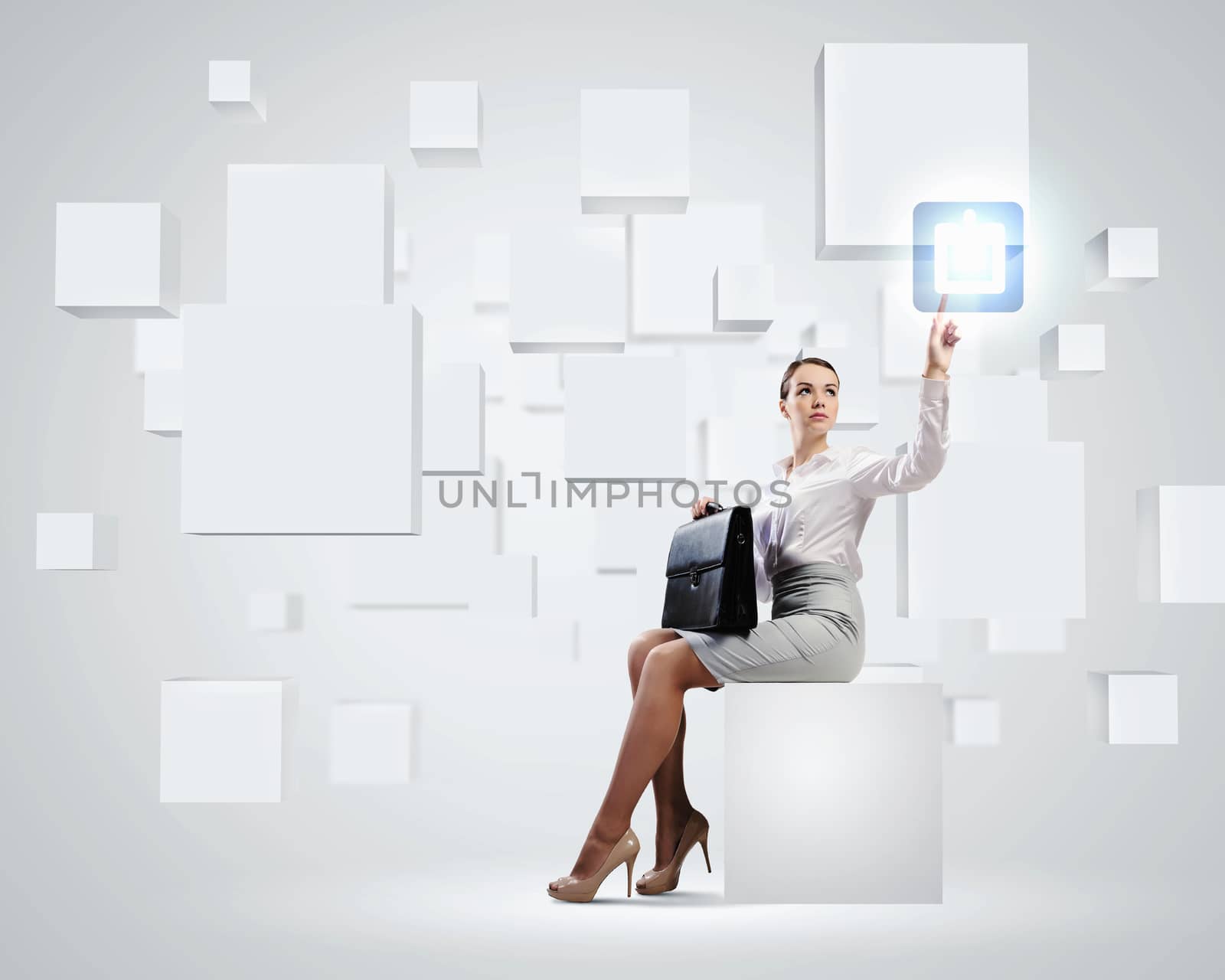 Image of elegant businesswoman sitting on white cube touching media button