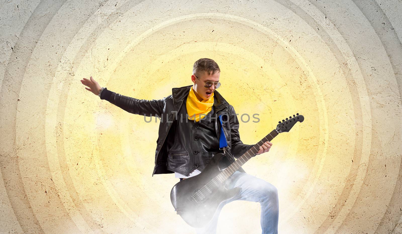 Young man, rock musician in jacket with guitar