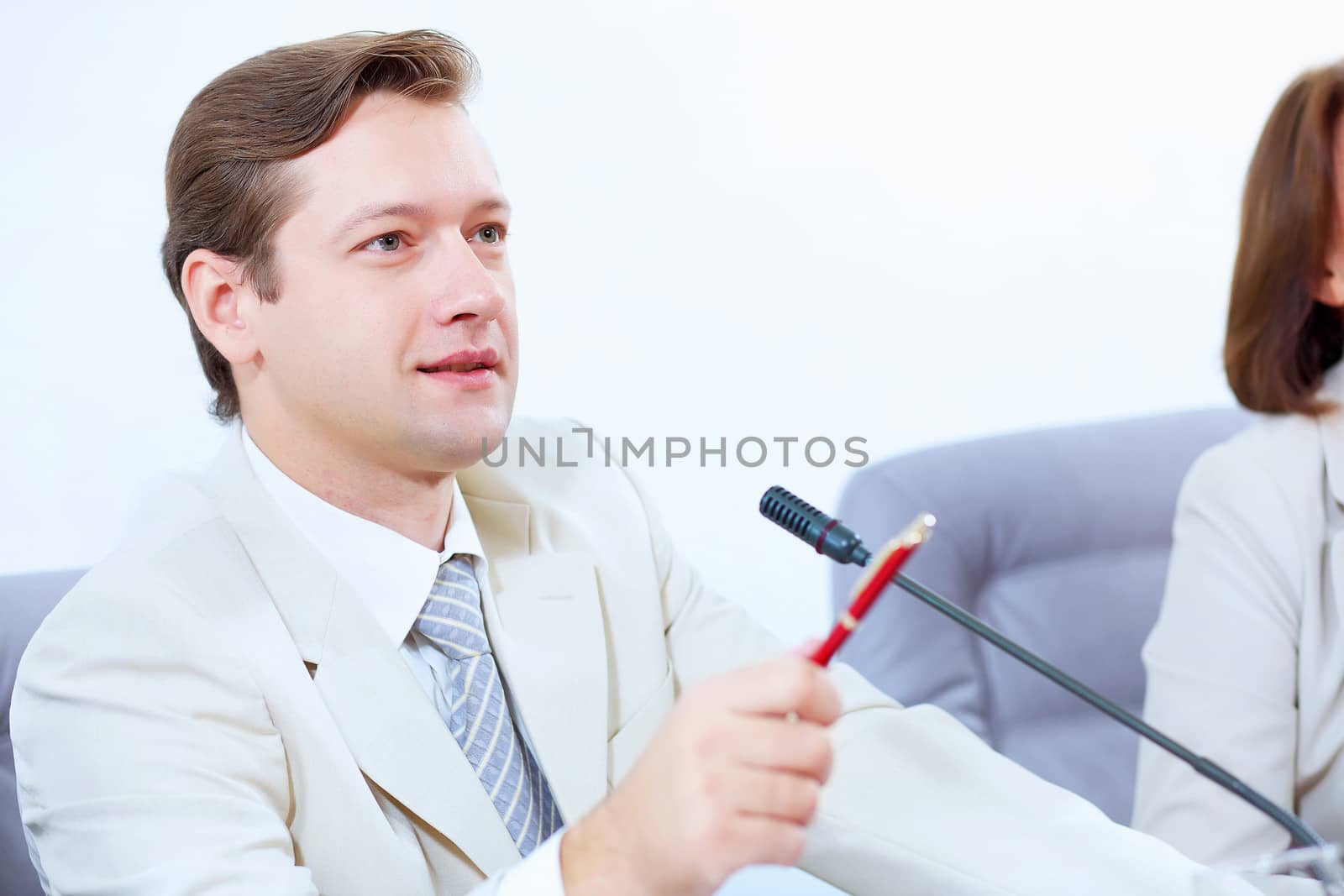 Image of young businessman sitting at table at business meeting