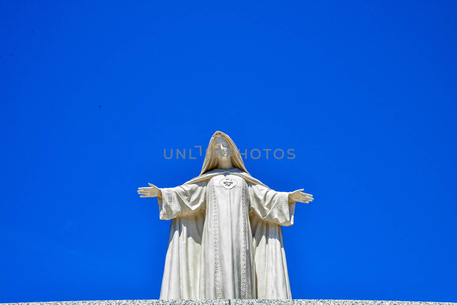 White Maria statue with blue sky1 by gjeerawut