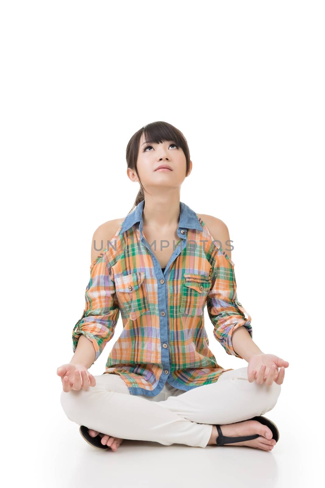 Portrait of a beautiful asian woman in yoga pose looking up. Isolated on the white background.