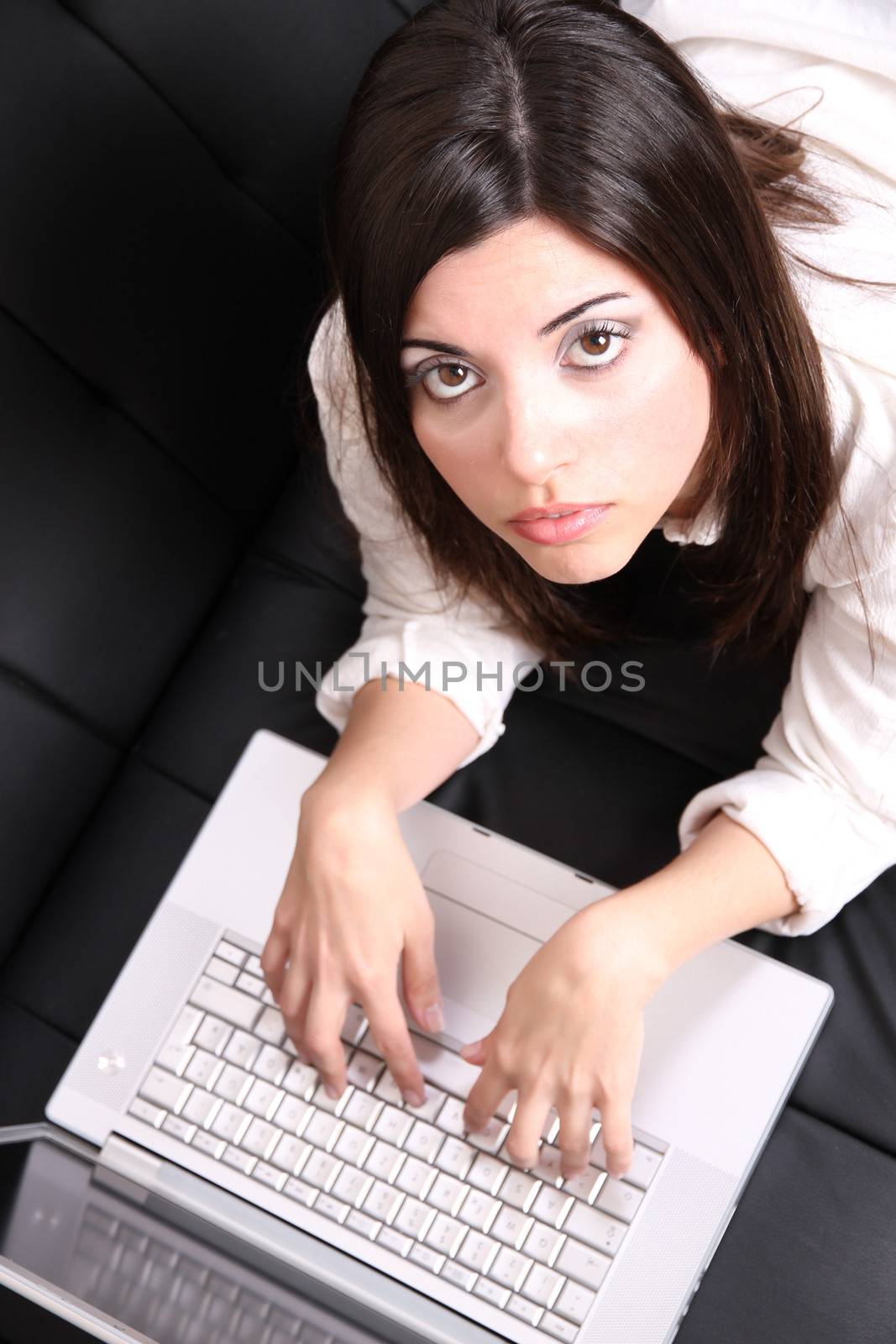 A young woman surfing on the Internet with a Laptop.  
