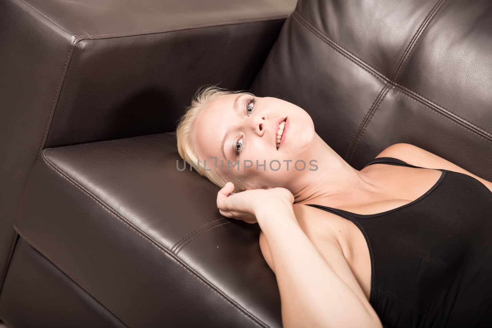 A blonde girl relaxing on a Sofa.