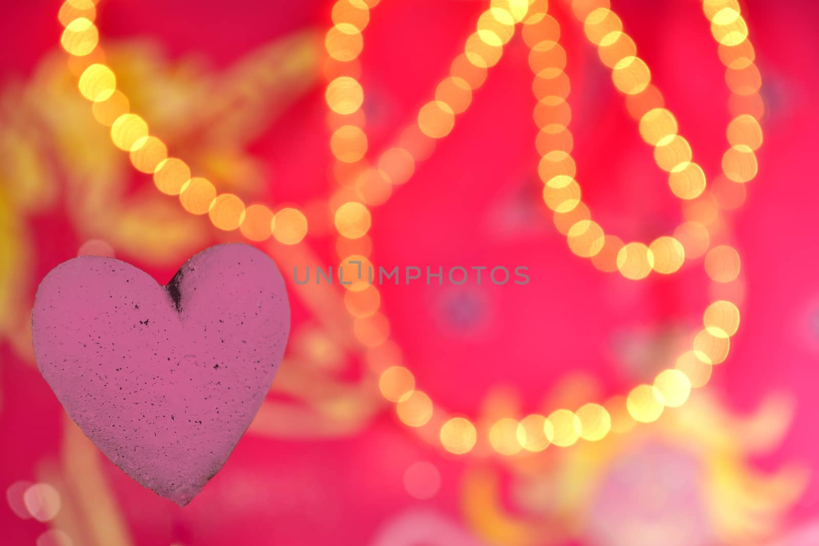 Purple Heart in front of a Pink background with lights