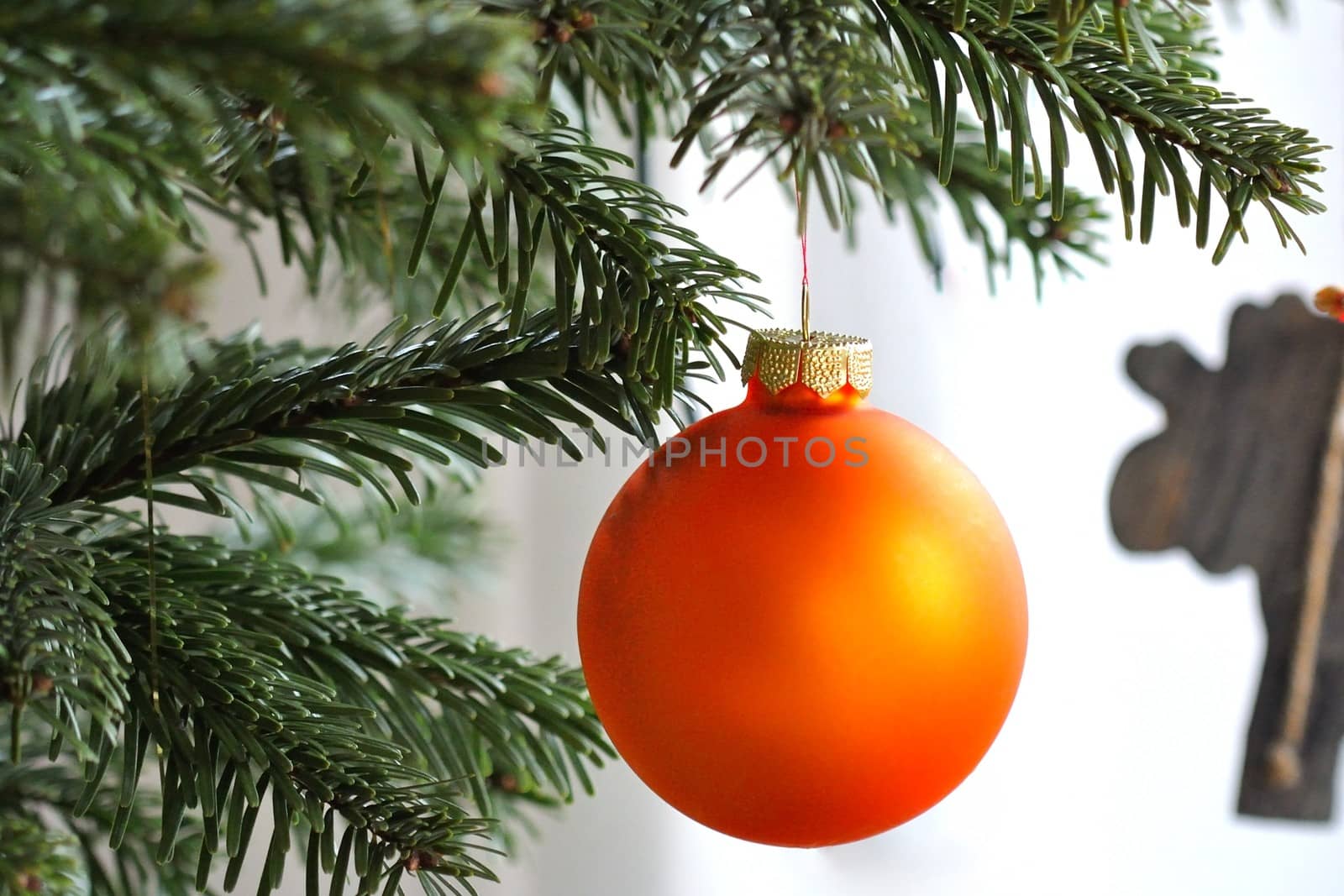 Orange Christmas ball hanging on a Christmas tree