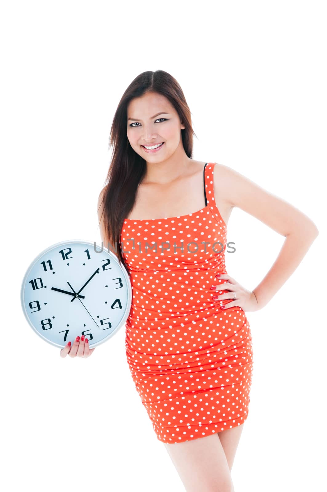 Portrait of an attractive young woman holding a clock over white background