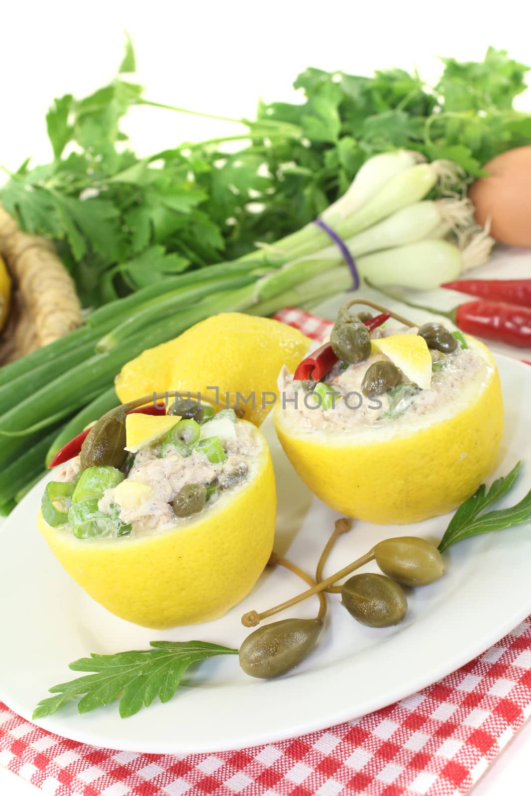 stuffed Lemons with tuna cream, capers and eggs on a light background