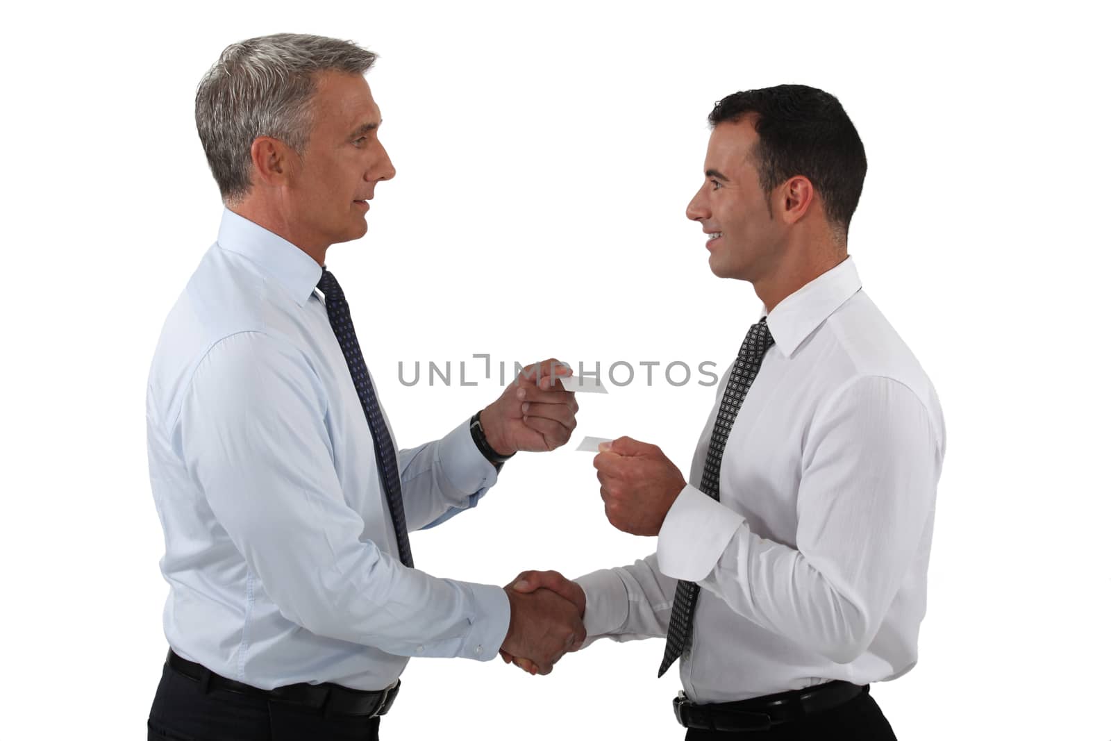 businessmen shaking hands and exchanging cards by phovoir