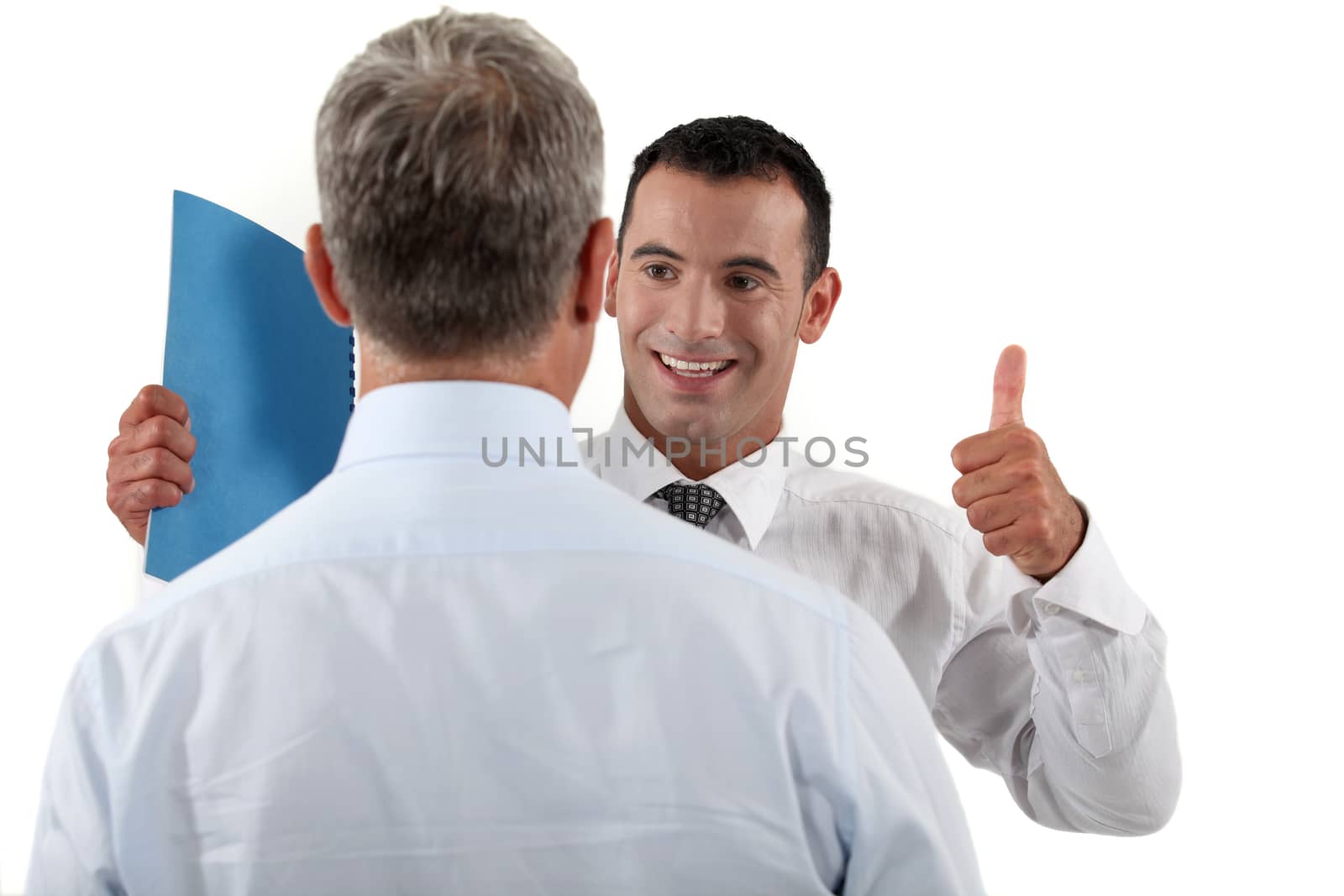 Businessman giving his colleague the thumbs up by phovoir