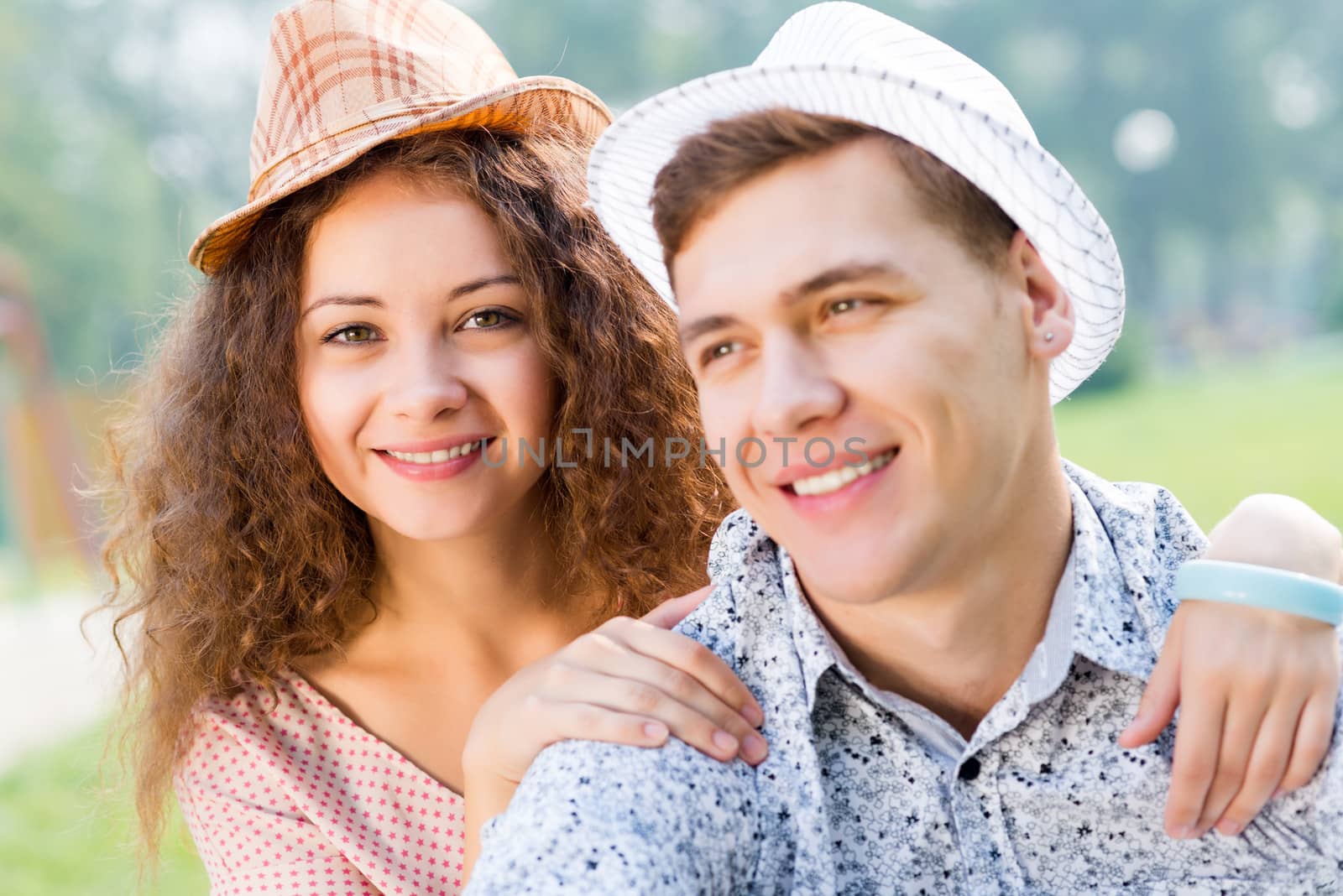 romantic couple lying on the grass in the summer park, spending time with loved ones