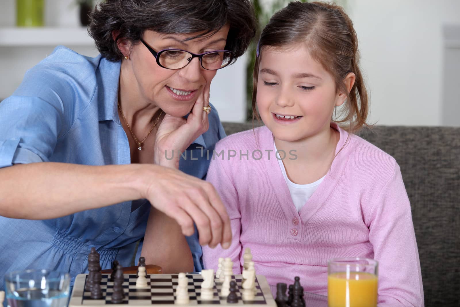 A mother and her daughter playing chess. by phovoir