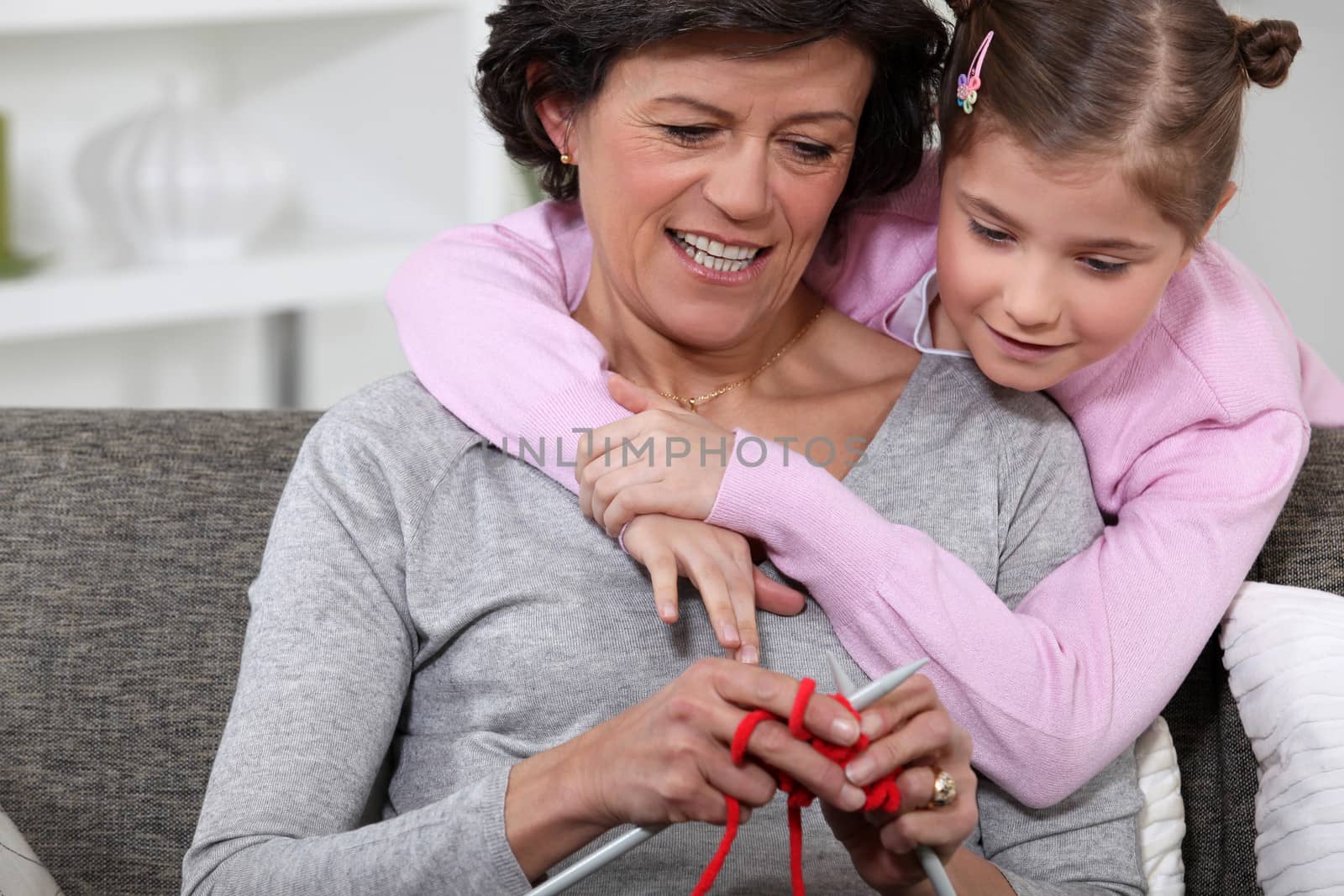 A mom showing how to knit to her daughter. by phovoir