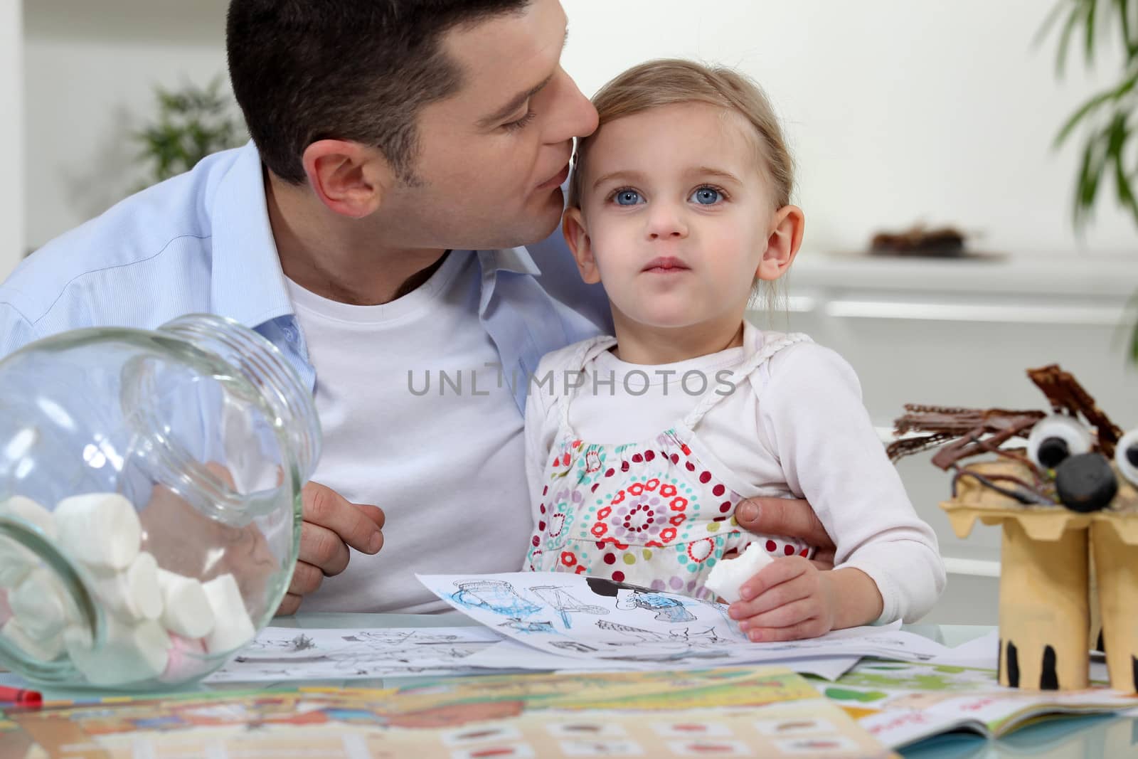 Man kissing his daughter by phovoir