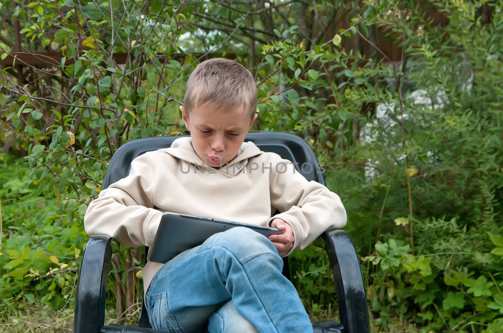 Outdoor shot of the boy with the tablet computer.