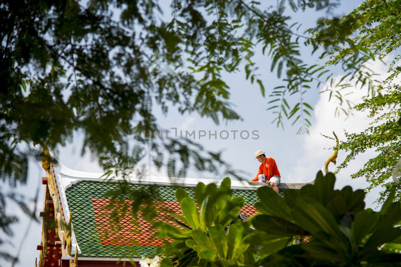 A Man repair roof of Temple by gjeerawut