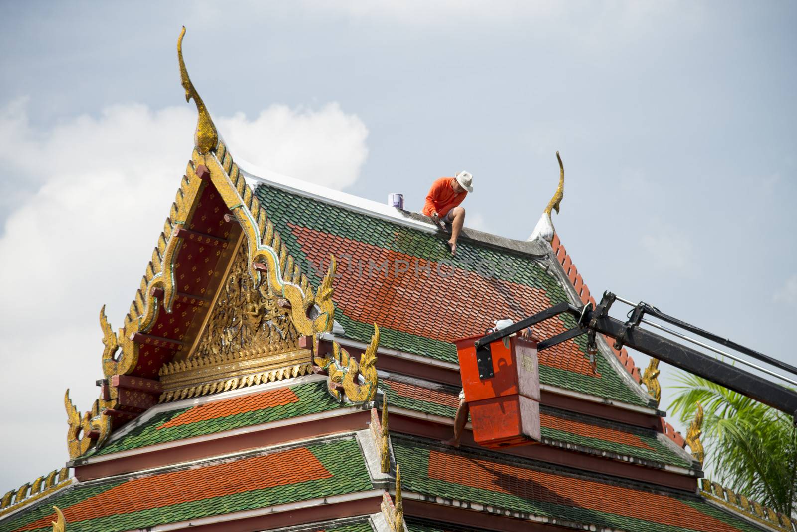 Men repair roof of Temple2 by gjeerawut