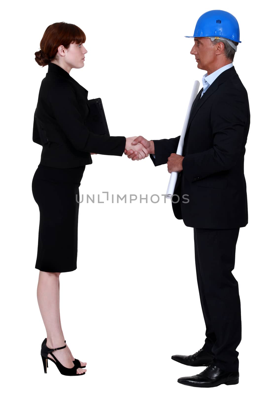 An architect and a businesswoman shaking hands. by phovoir