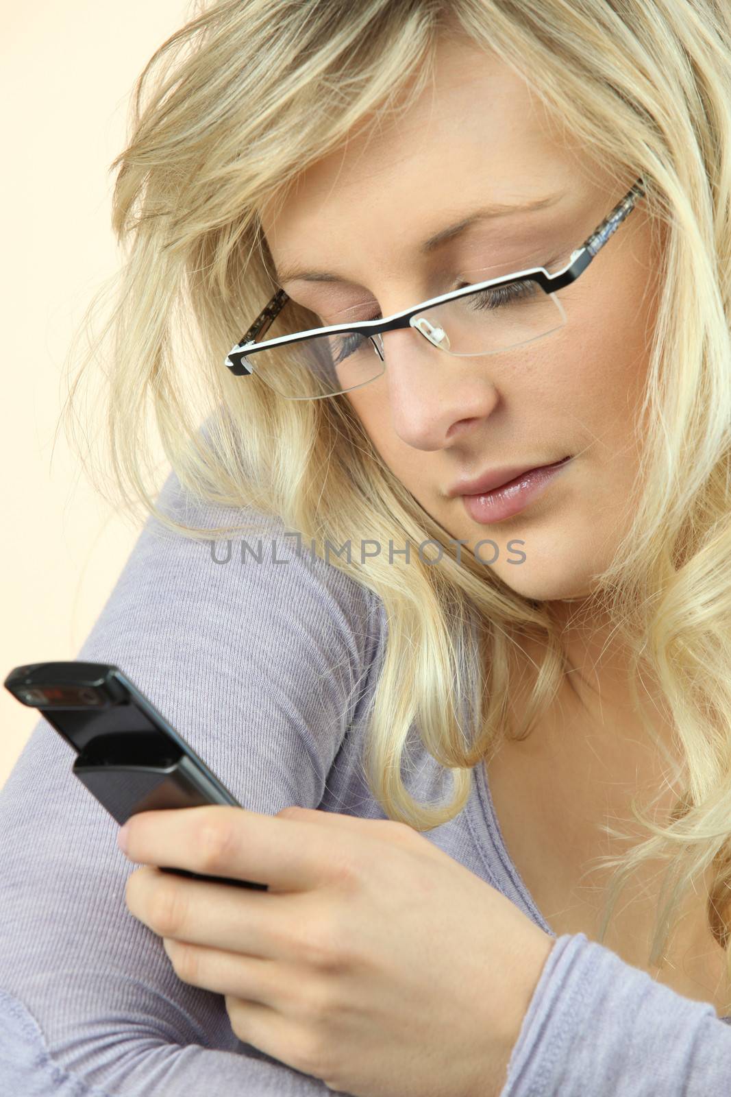 Woman wearing glasses sending a text message by phovoir