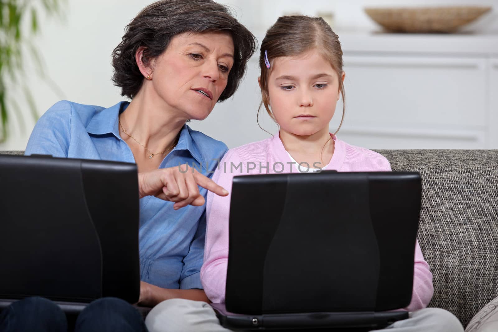 Girl with her grandmother and laptop computers by phovoir