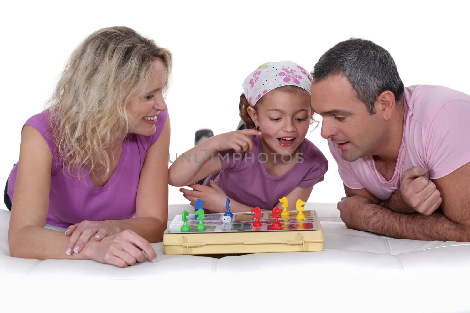 Little girl learning chess with her parents. by phovoir