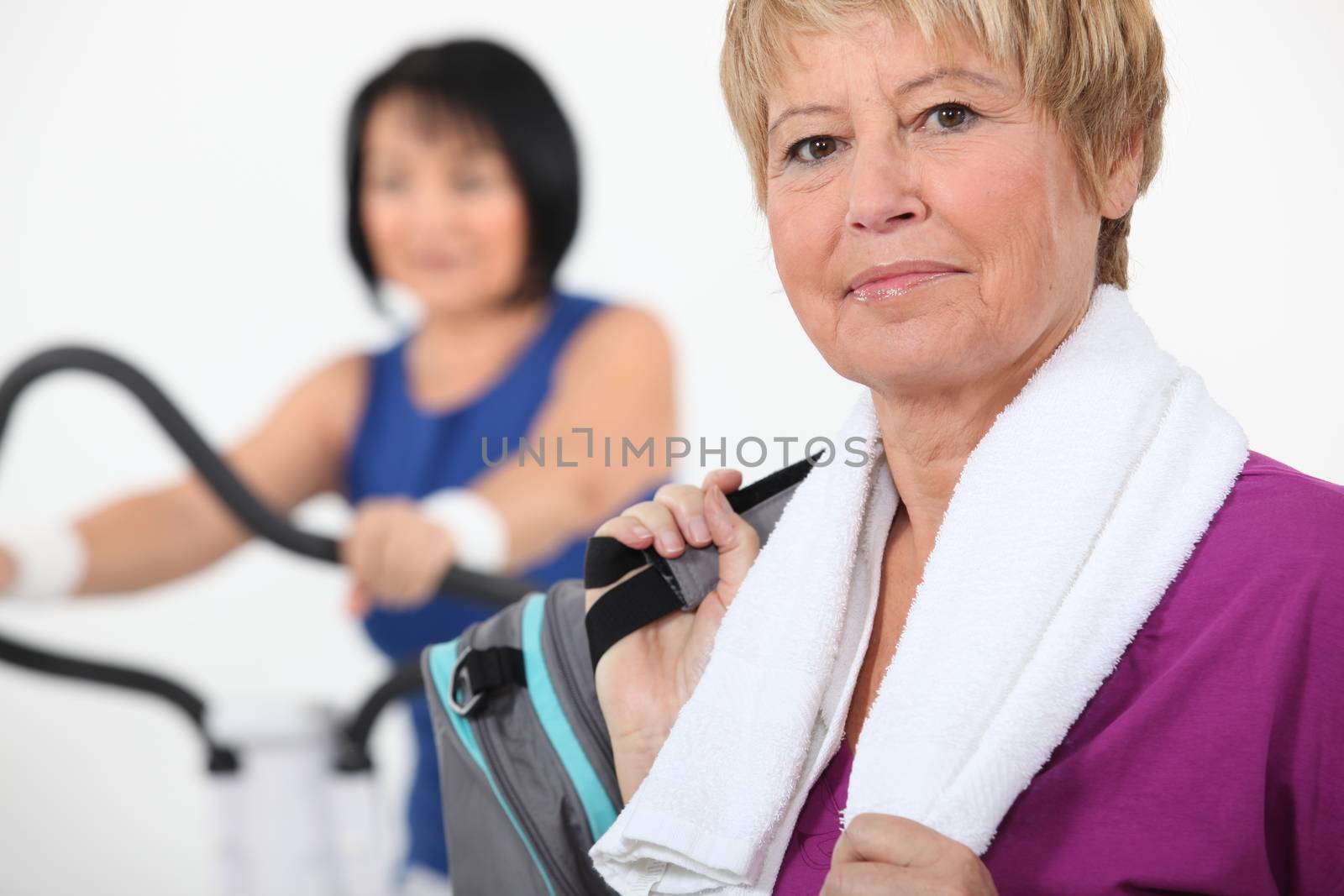 Women using gym equipment by phovoir