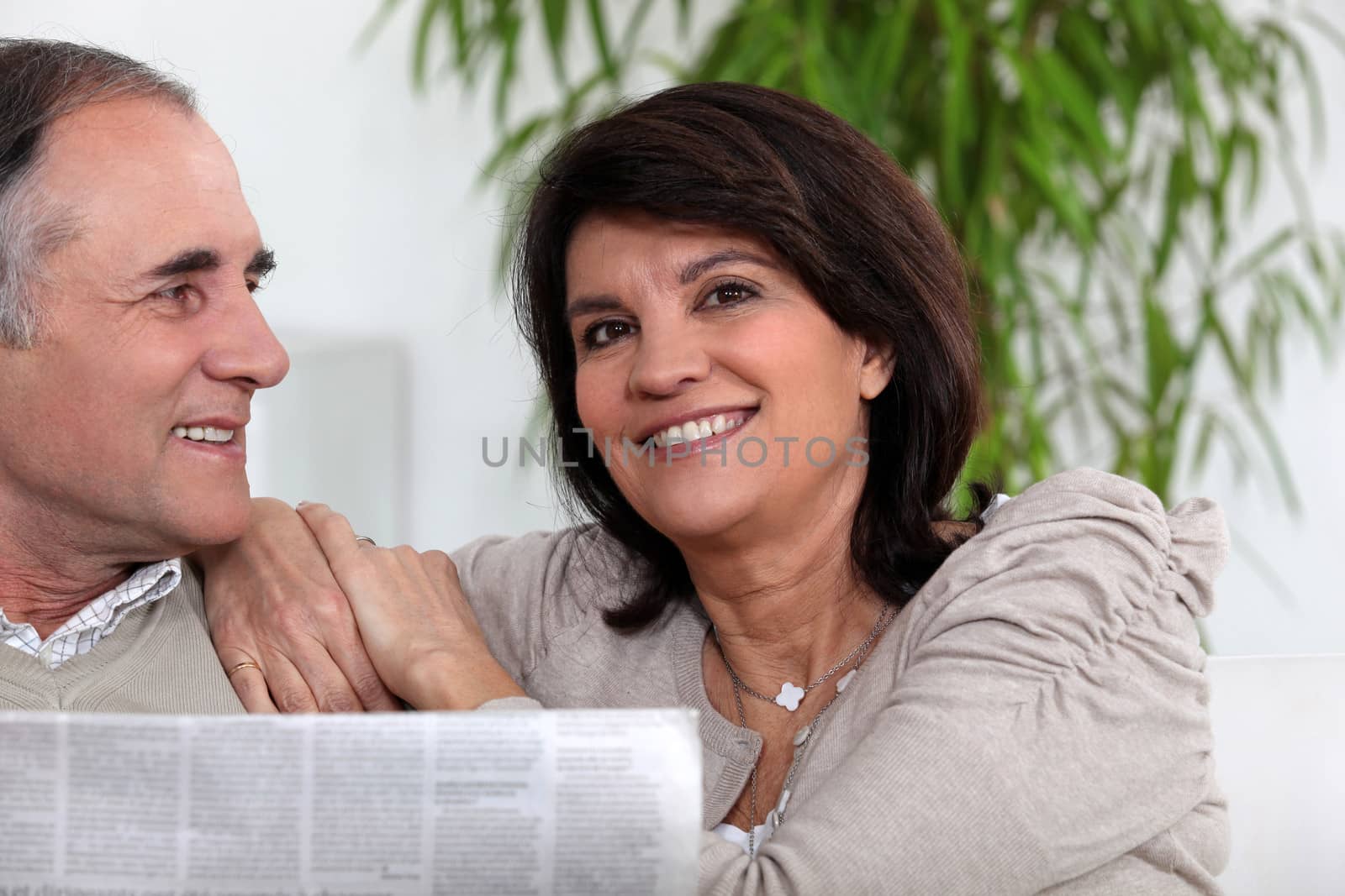Senior couple reading the newspaper by phovoir