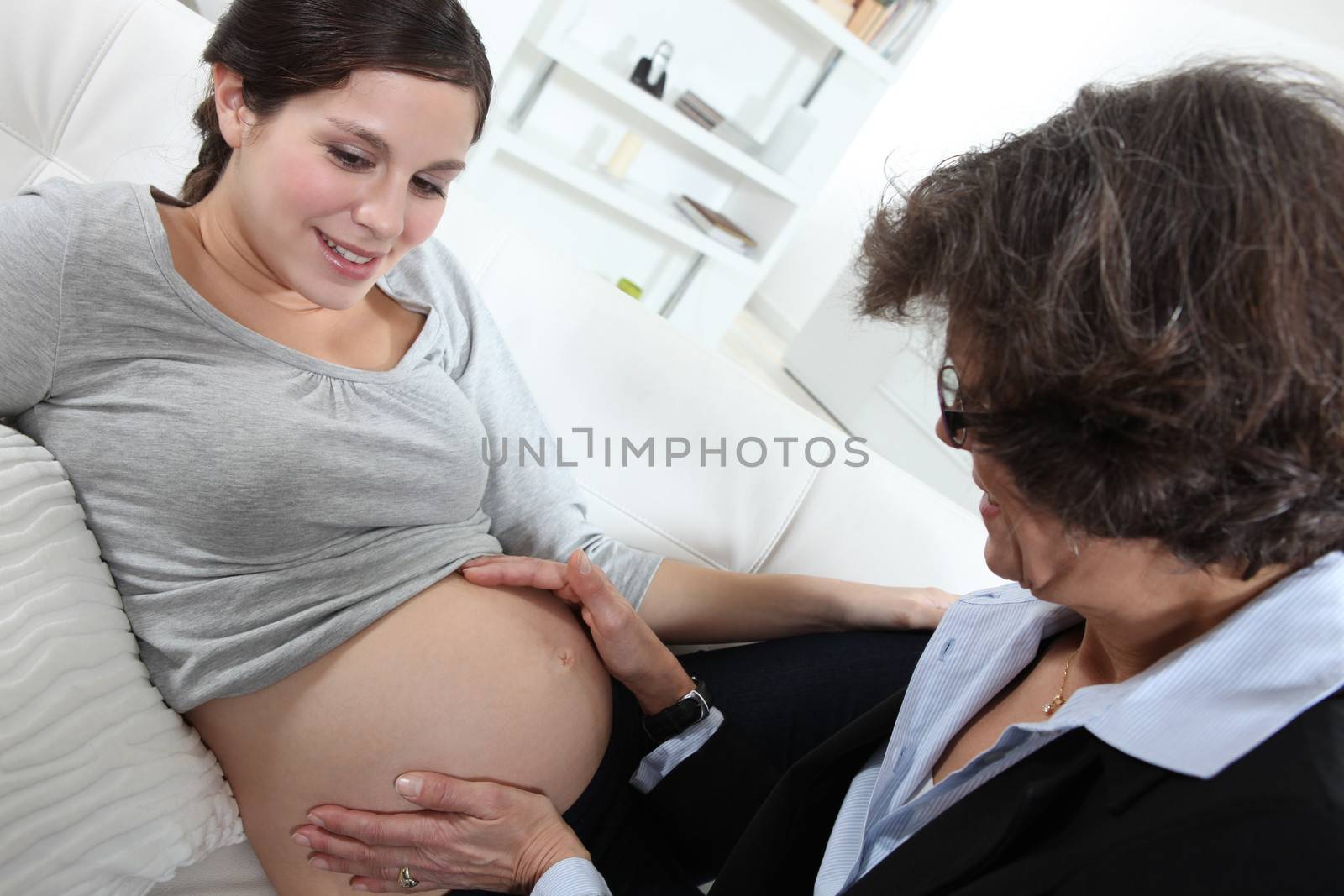 Doctor checking pregnant lady's progress by phovoir