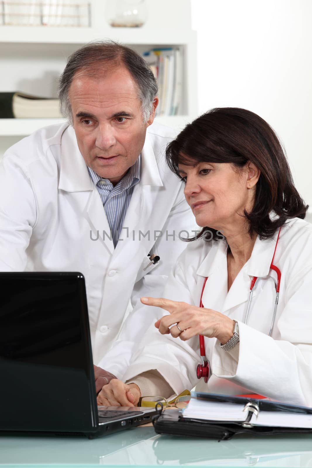 Doctors looking at a computer and sharing their opinions by phovoir