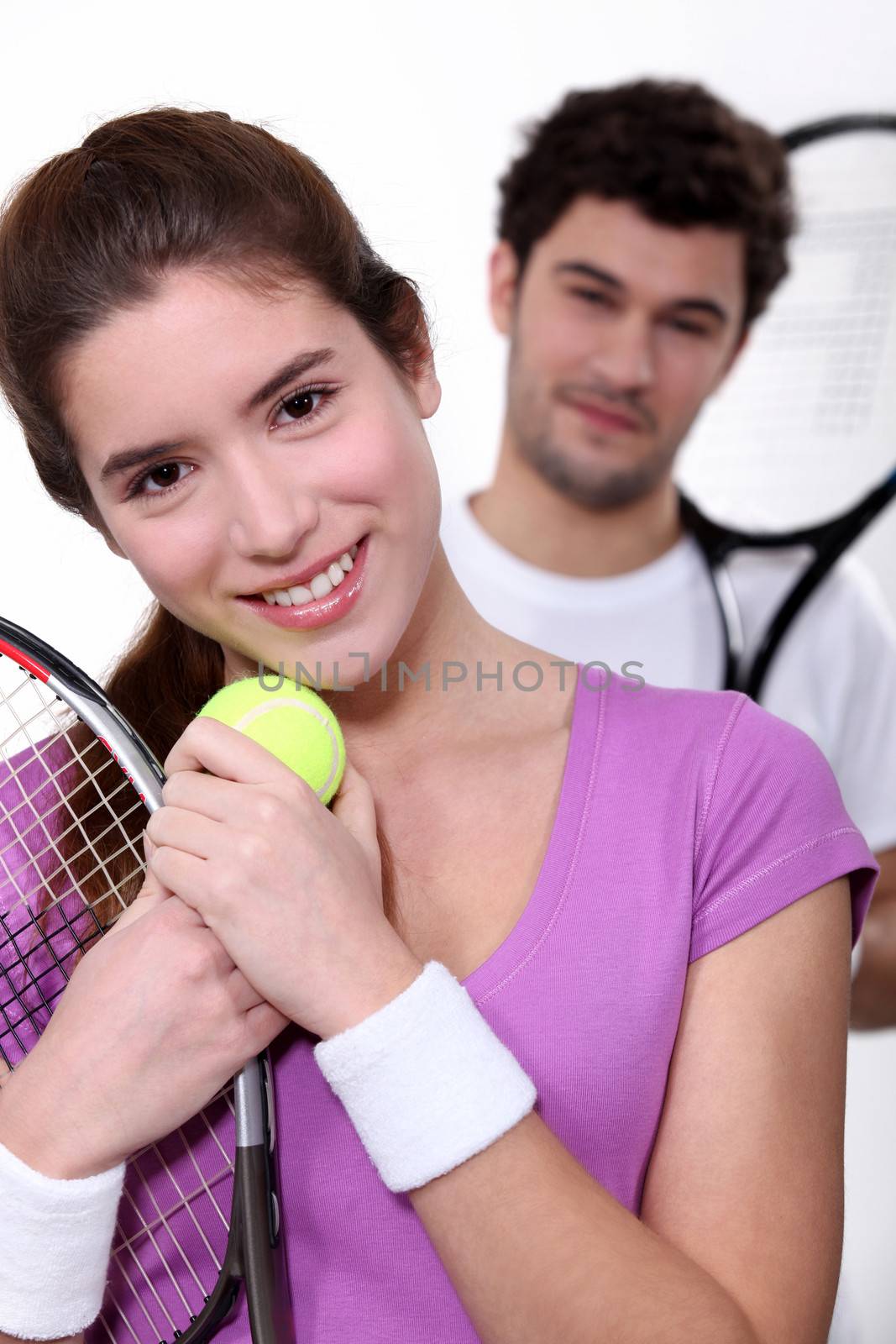 Young couple with tennis equipment by phovoir