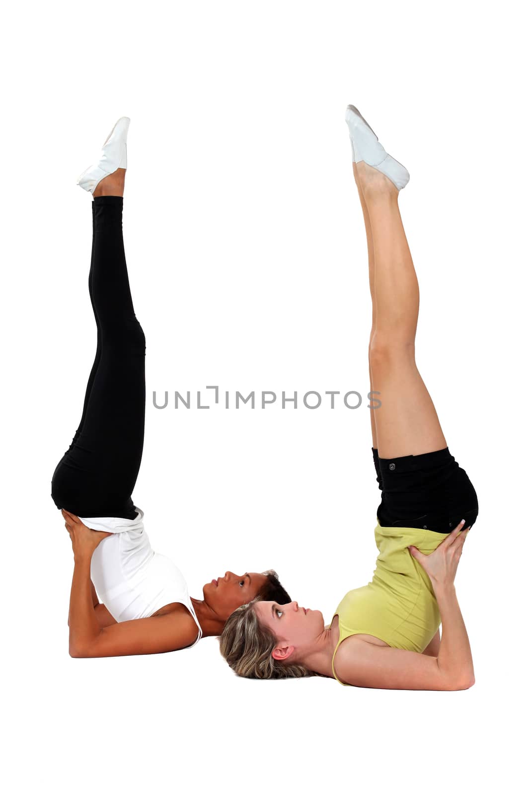 Young women performing shoulder stands by phovoir