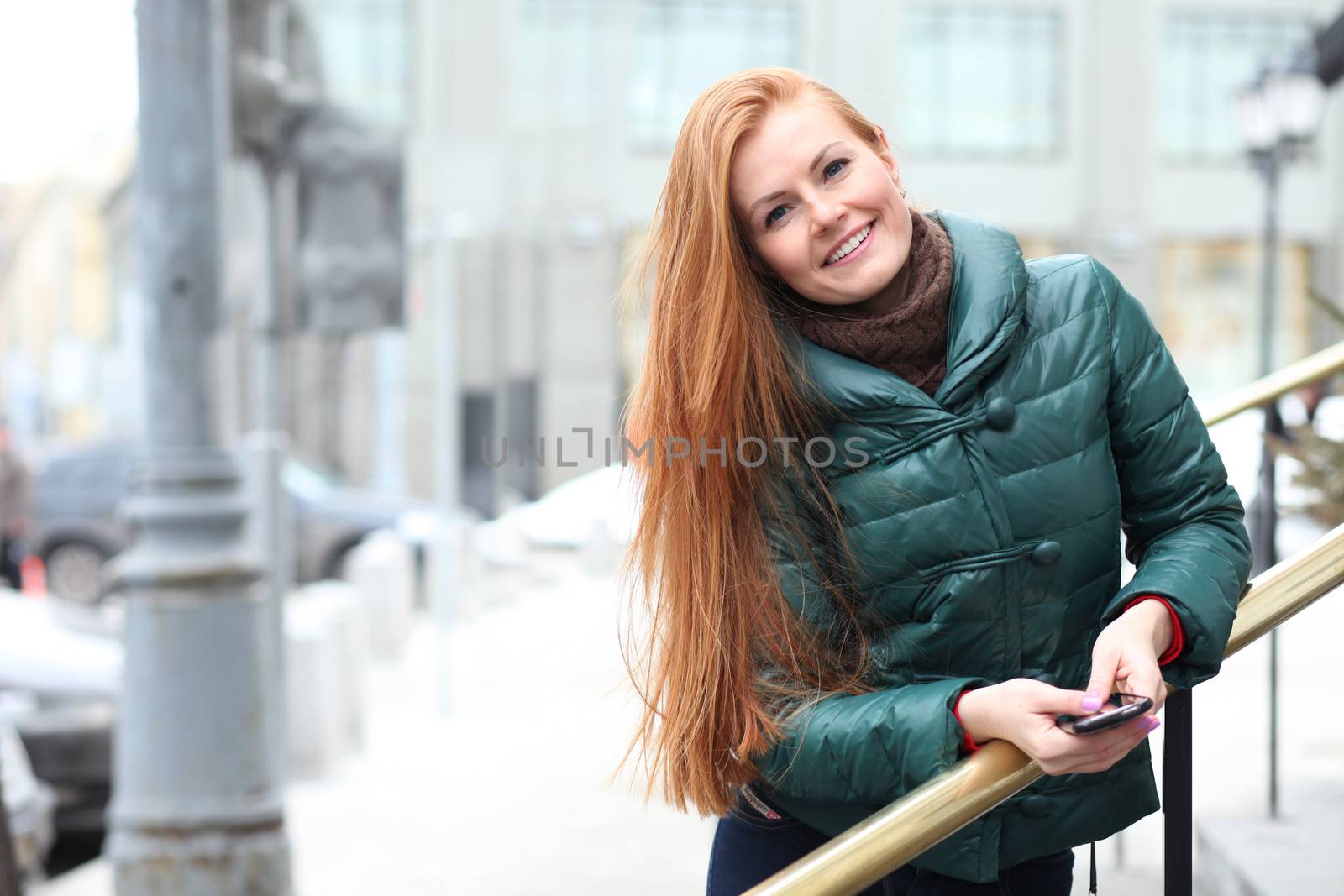 Happy young woman in autumn city by andersonrise