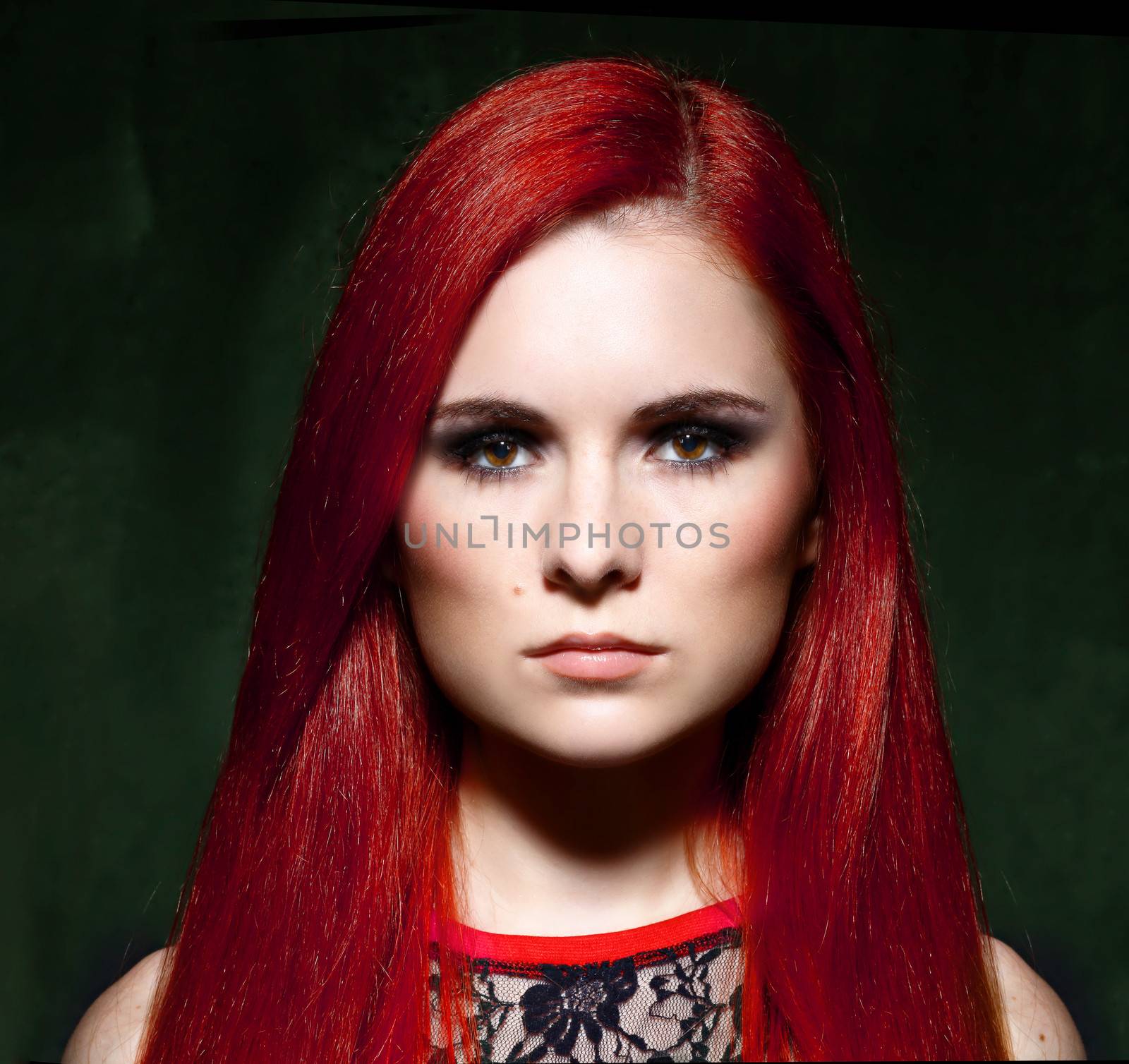 Young beautiful red hair woman in dark studio by andersonrise