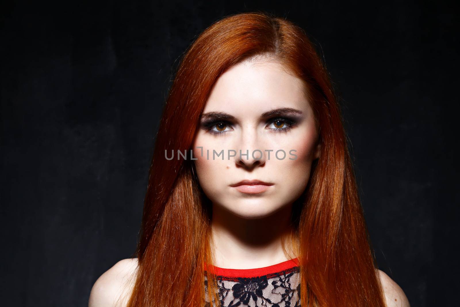 Young beautiful red hair woman in dark studio