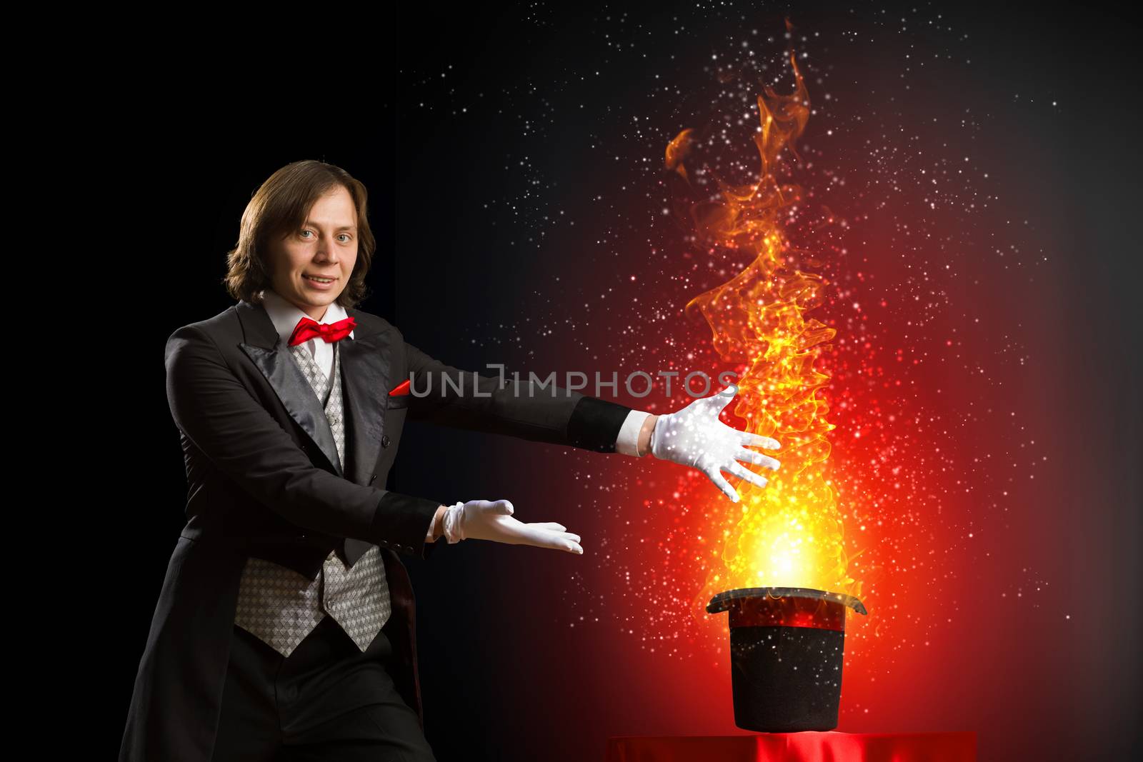 Image of magician holding hat with lights and fumes going out