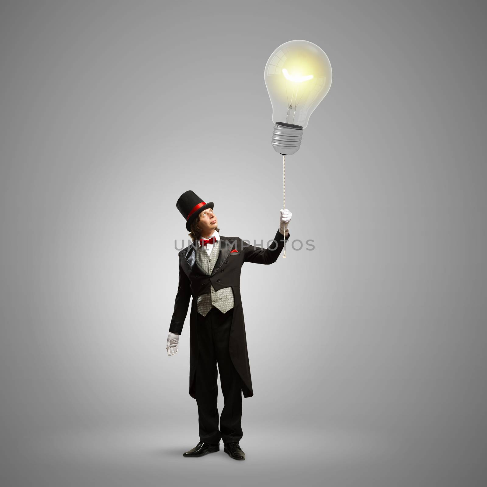 Image of man magician showing trick against color background