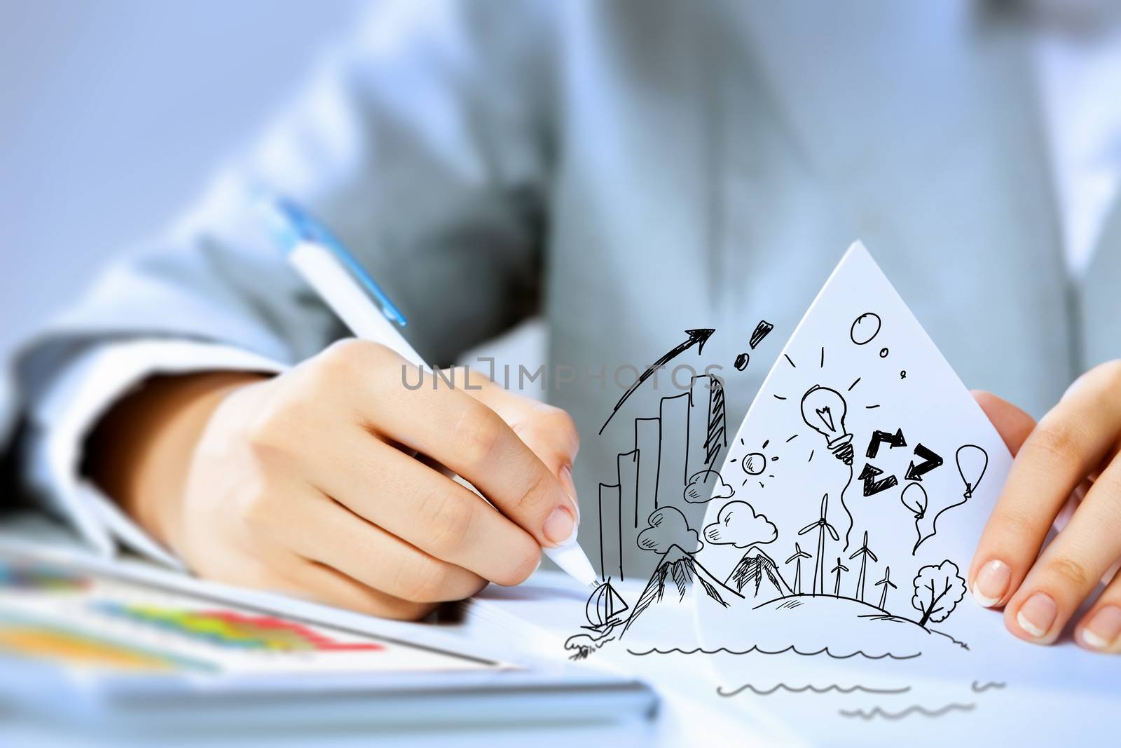 Image of businesswoman sitting at table and drawing sketch