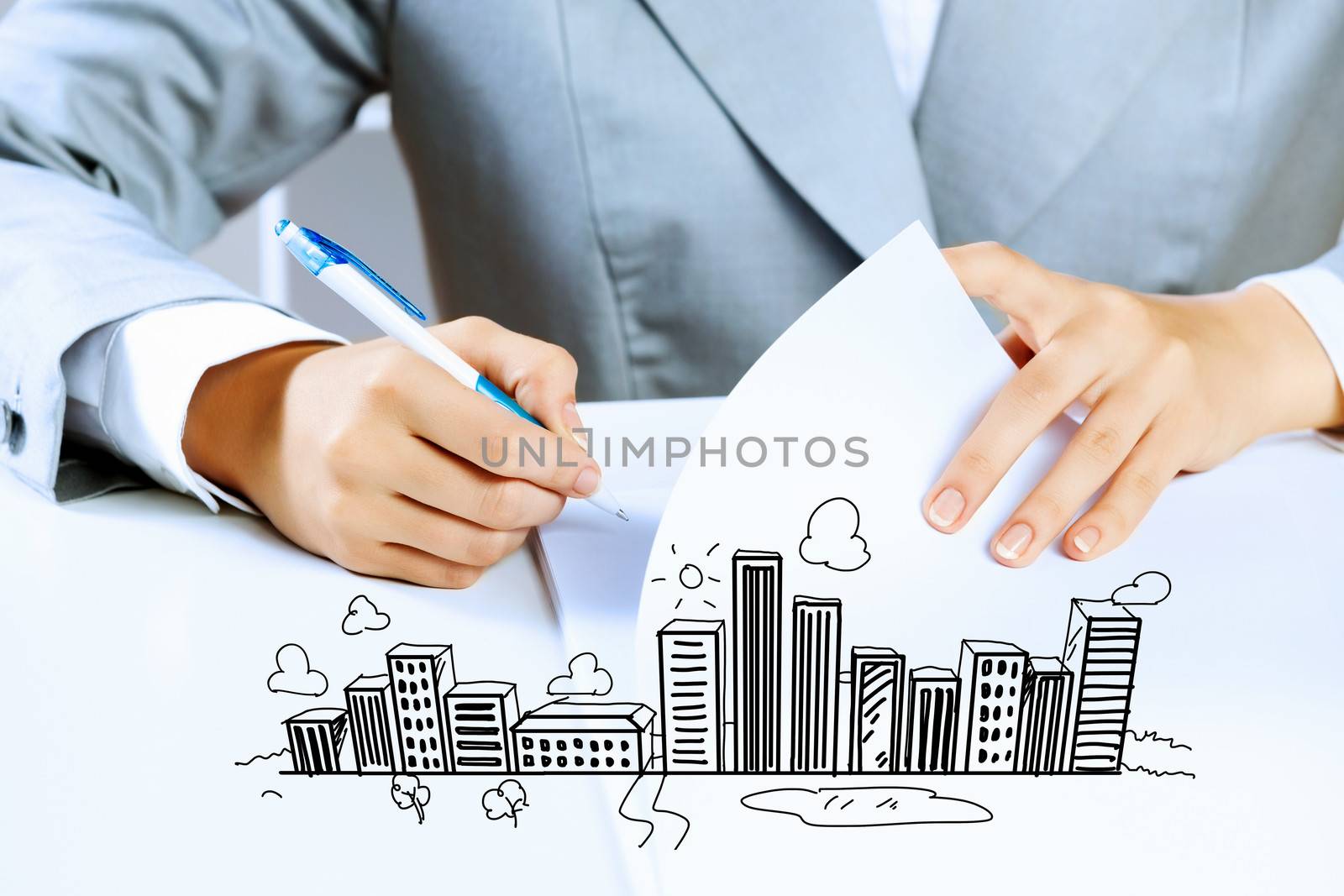 Image of businesswoman sitting at table and drawing sketch