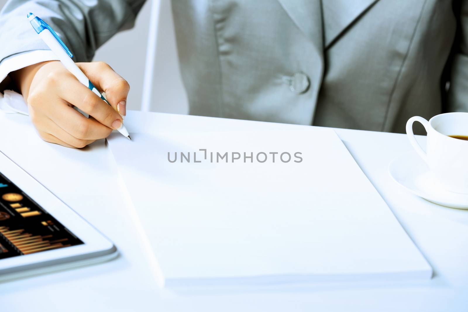 Image of businesswoman sitting at table and drawing sketch