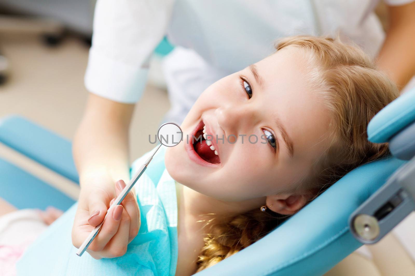 Little girl sitting in the dentists office